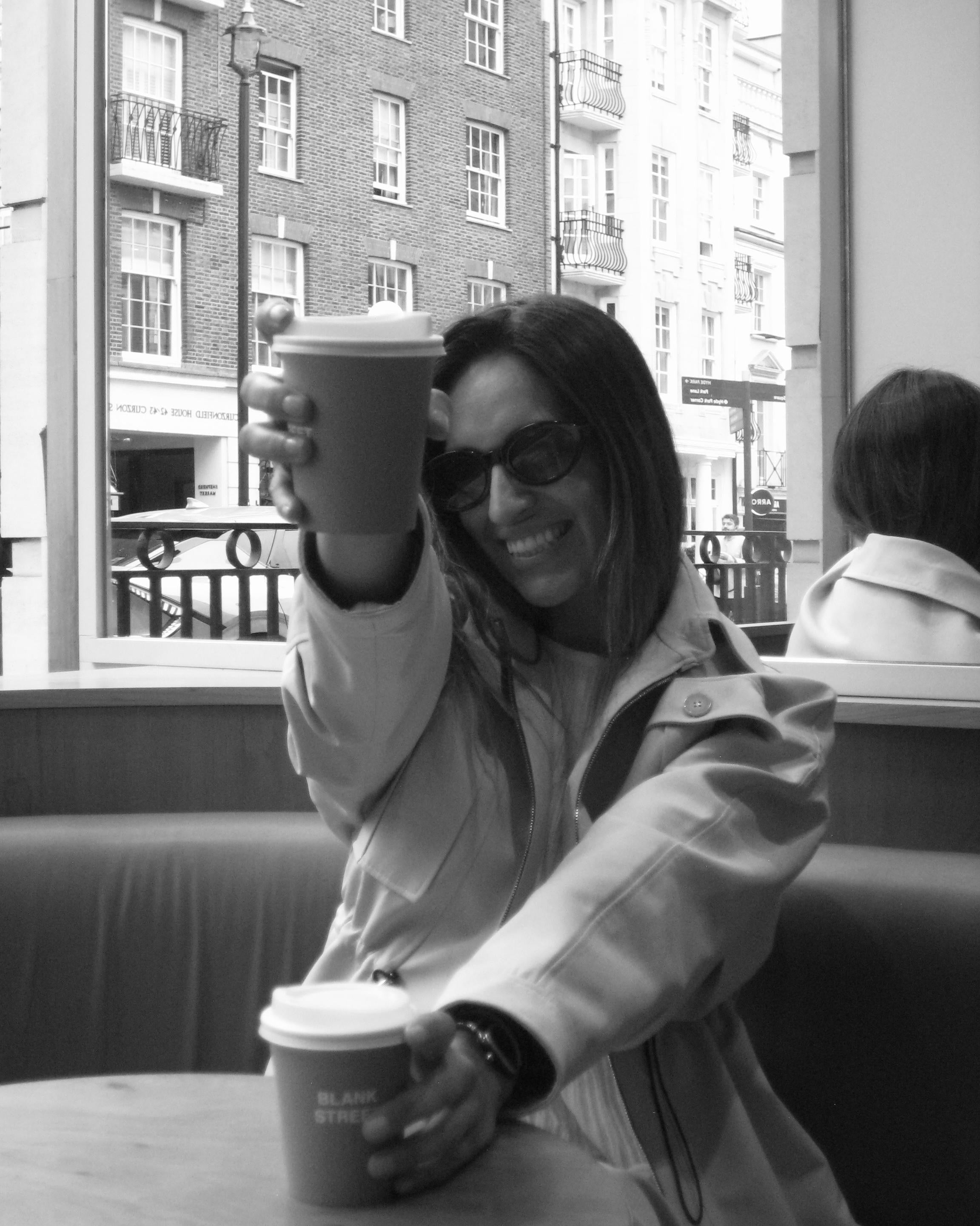 Person holding a coffee cup in an urban setting